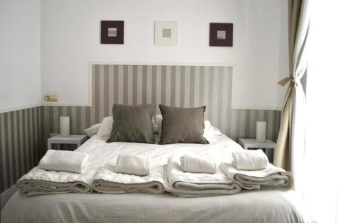 a bed with a white comforter and pillows at Casas y Patios de Sevilla in Seville