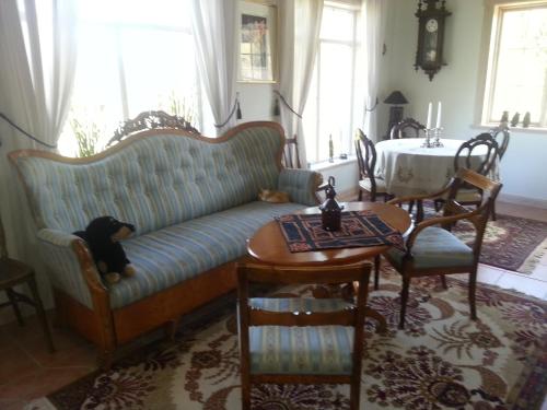 a couch with a stuffed dog sitting on it in a living room at Kullsbjörken Bed & Breakfast in Tällberg