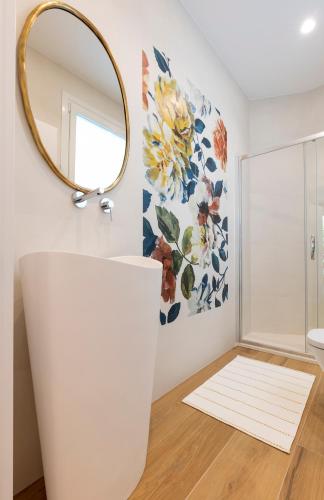 a bathroom with a mirror and a white sink at BIG 4 ROOMS in a Centric Home Parking Included in San Sebastián