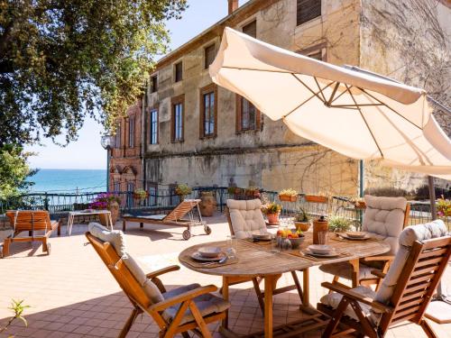 une terrasse avec une table, des chaises et un parasol dans l'établissement Villa Gabriella by Interhome, à Formia