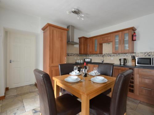 a kitchen with a wooden dining table and chairs at Holiday Home Pebbles- Marazion by Interhome in Marazion