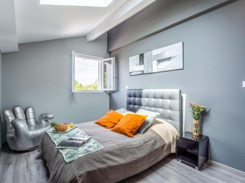 sypialnia z łóżkiem z pomarańczowymi poduszkami i oknem w obiekcie Apartment Maison Elbarren by Interhome w mieście Urrugne