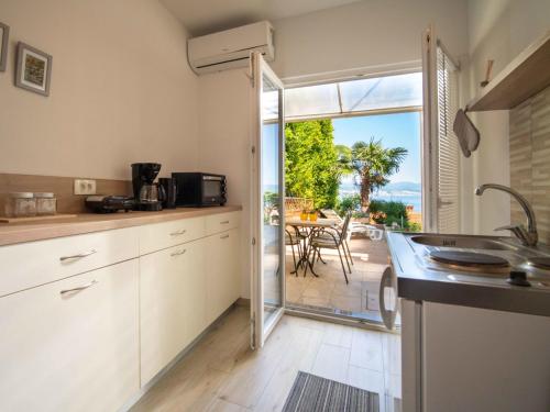 a kitchen with a view of a patio with a table at Holiday Home Bono by Interhome in Opatija