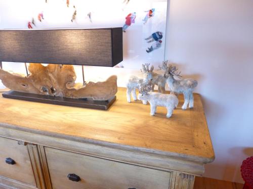 a lamp on a dresser with deer figurines on it at Chalet Chalet Astoria by Interhome in Crans-Montana