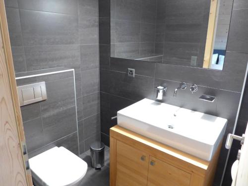 a bathroom with a white sink and a mirror at Chalet Chalet Astoria by Interhome in Crans-Montana