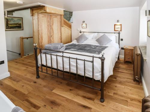 1 dormitorio con 1 cama y suelo de madera en Ha'penny Cottage, en Holmfirth