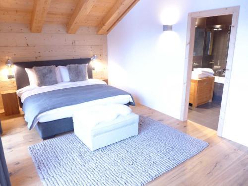a bedroom with a bed and a blue rug at Chalet Chalet Astoria by Interhome in Crans-Montana