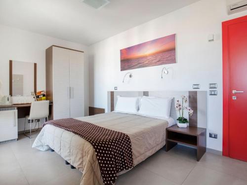 a bedroom with a large bed and a kitchen at Navicri B&B in Vieste