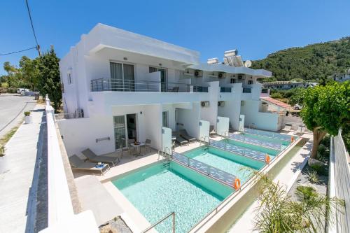a house with two swimming pools in front of it at Stay Helios in Faliraki