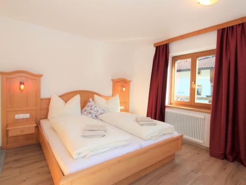 a bedroom with a bed with white sheets and a window at Holiday Home Sonnblick by Interhome in Uderns
