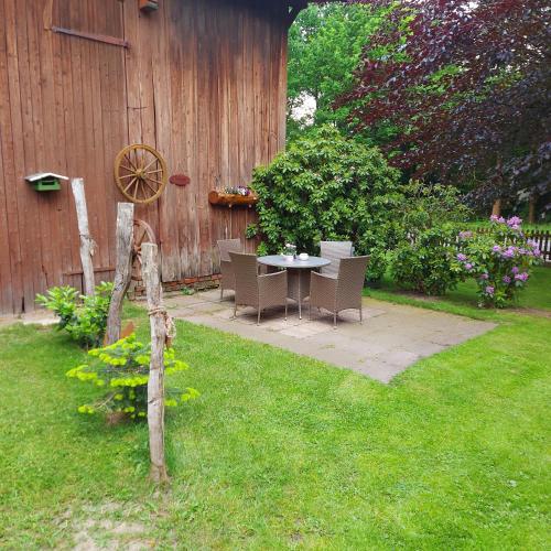 a patio with a table and chairs in a yard at Röhrshof in Bispingen