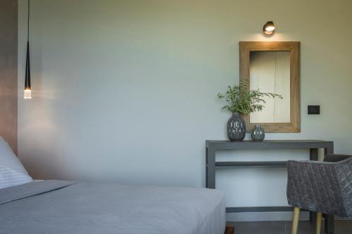 a bedroom with a bed and a mirror and a table at Narcissos Villa in Argostoli