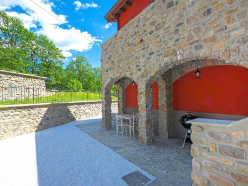 ein Steingebäude mit einem Tisch und Stühlen auf einer Terrasse in der Unterkunft Holiday Home Agr- Castello della Mugazzena by Interhome in Tresana