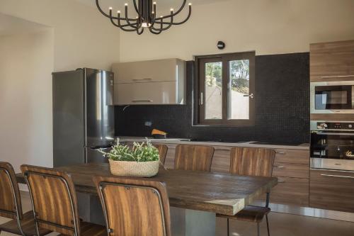 a kitchen with a wooden table with chairs and a dining room at Narcissos Villa in Argostoli