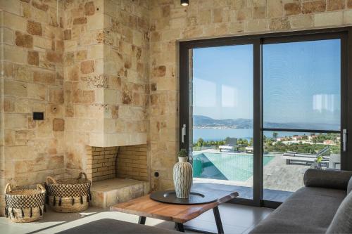 a living room with a stone wall and a fireplace at Narcissos Villa in Argostoli