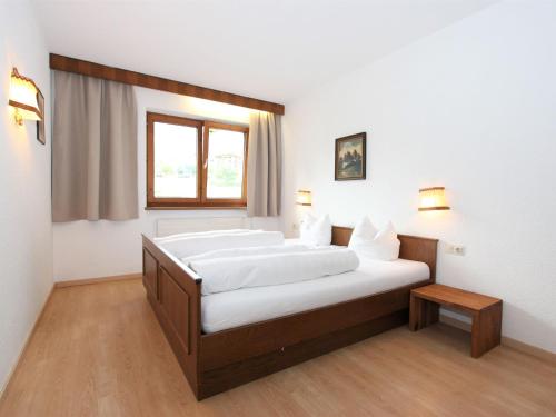 フューゲンにあるApartment Römerhof-4 by Interhomeの白い壁の客室で、ベッド2台、窓が備わります。