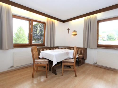 ein Esszimmer mit Tisch und Stühlen und Fenstern in der Unterkunft Apartment Römerhof-4 by Interhome in Fügen