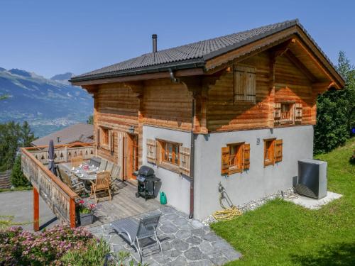 a small wooden house with a patio and a television at Chalet Le Muveran V8 by Interhome in Nendaz