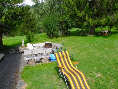 two benches sitting in the grass next to a picnic table at Apartment Fricktalerhuus Apt-1 by Interhome in Surava