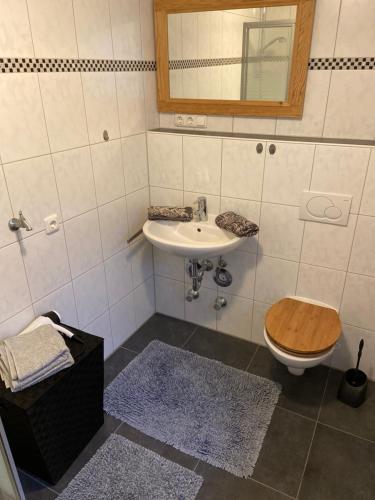 uma casa de banho com um lavatório, um WC e um espelho. em Ferienwohnung Königsberger Klosterblick em Ettal