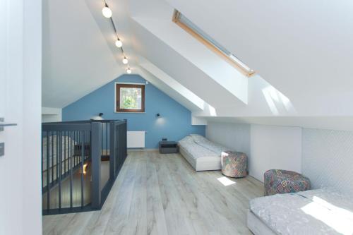 um quarto no sótão com paredes azuis e uma escada em APARTAMENT VIVALDI em Mosty