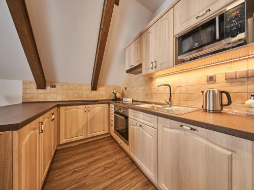 a kitchen with wooden cabinets and a sink at Apartment Na Pomezkách by Interhome in Horní Malá Úpa