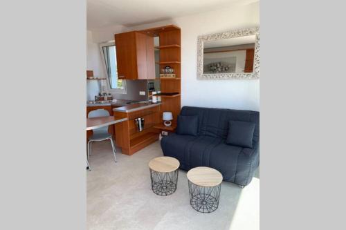 un salon avec un canapé bleu et une cuisine dans l'établissement LA RESIDENCE, à La Baule