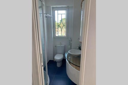 une salle de bain avec baignoire et toilettes et une fenêtre dans l'établissement LA RESIDENCE, à La Baule