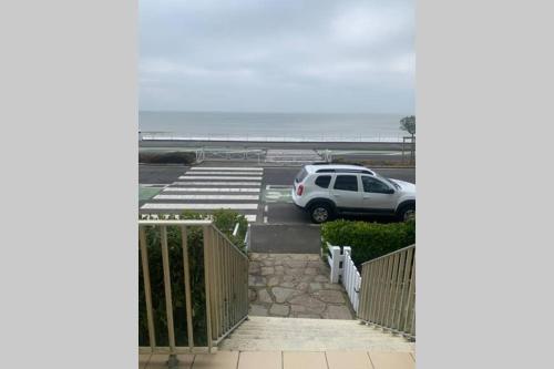 un coche aparcado en un estacionamiento junto al océano en LA RESIDENCE, en La Baule
