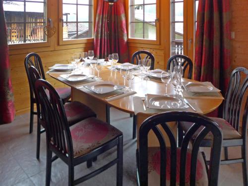 - une table en bois avec des chaises et des verres à vin dans l'établissement Chalet Chalet A Coeur by Interhome, à Grimentz