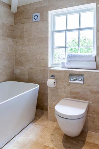 a bathroom with a tub and a toilet and a window at The Borough Lancaster in Lancaster