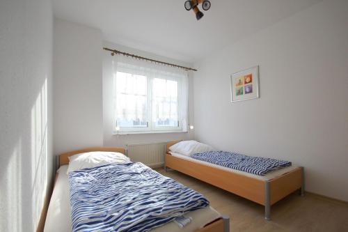 two beds in a room with a window at Ferienwohnung am Potenberg FeWo 6 - Balkon in Binz