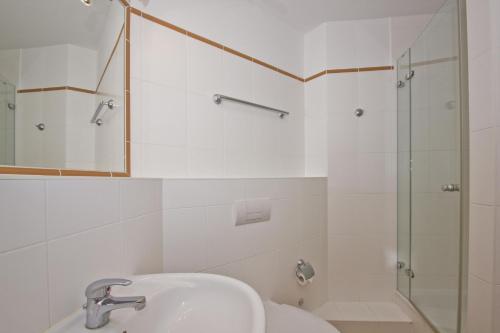 ein weißes Bad mit einem Waschbecken und einer Dusche in der Unterkunft Villa Laetitia FeWo 16 - strandnah, Balkon in Binz