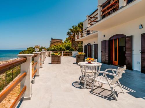 eine Terrasse mit Tischen und Stühlen am Meer in der Unterkunft Apartment Nina by Interhome in Caronia Marina