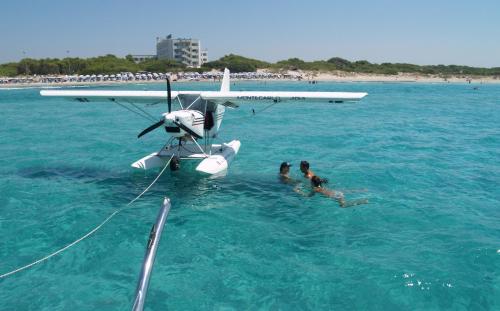 two people in the water next to a plane in the water at Ecoresort Le Sirene - Caroli Hotels in Gallipoli