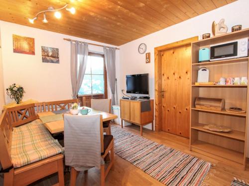 a kitchen and dining room with a table and a television at Apartment Laura by Interhome in Zell am Ziller
