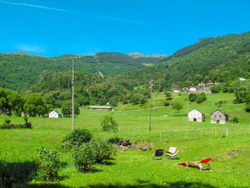 two chairs in a field with mountains in the background at Holiday Home Rustico al Campett by Interhome in Ponto Valentino