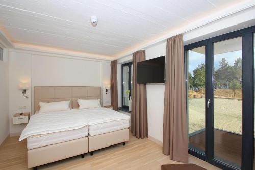 a bedroom with a bed and a large window at App Prora Solitaire FeWo 8 Balkon, Strand, Wellness in Binz