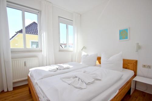 uma cama branca num quarto com uma janela em Villa Linde FeWo 30 - Balkon em Göhren