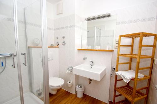 uma casa de banho com um WC, um lavatório e um chuveiro em Villa Linde FeWo 30 - Balkon em Göhren