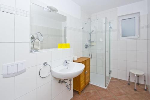 une salle de bain blanche avec lavabo et douche dans l'établissement zentral aber ruhig, Balkon, gratis Nutzung vom AHOI Erlebnisbad und Sauna in Sellin - Villa Elisenhof FeWo 2, à Göhren