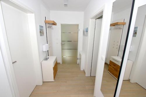 a hallway with a mirror and a dressing room at strandnahes Ferienhaus mit eigener Sauna und Kamin - Ferienhaus am Dünenstrand in Baabe