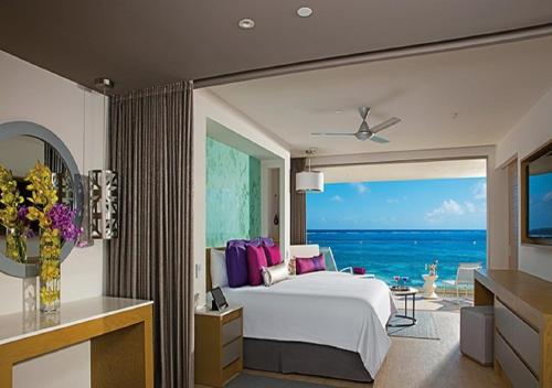 Schlafzimmer mit einem Bett und Meerblick in der Unterkunft Breathless Riviera Cancun Resort & Spa - Adults Only - All inclusive in Puerto Morelos