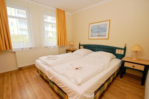 a bedroom with a large bed with white sheets at Terrasse, gratis Nutzung vom AHOI Erlebnisbad und Sauna - Meeresblick FeWo 10 in Göhren