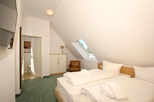 a bedroom with two white beds in a attic at Strandresort Rex Rugia Ferienwohnung 14-6 mit Sauna- und Schwimmbadnutzung im AHOI Sellin in Lobbe