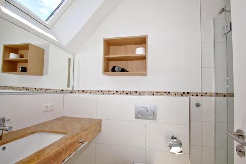 a bathroom with a sink and a shower at Strandresort Rex Rugia Ferienwohnung 14-6 mit Sauna- und Schwimmbadnutzung im AHOI Sellin in Lobbe