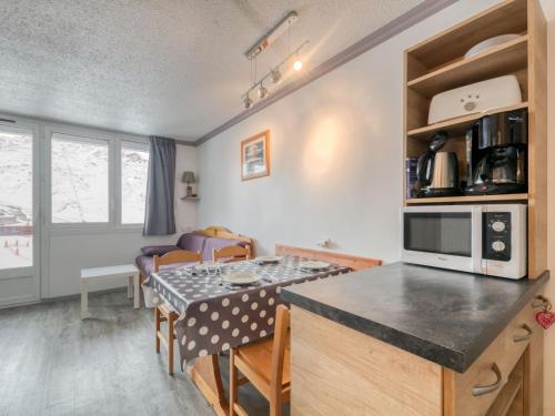 uma cozinha e sala de estar com uma mesa e um balcão em Apartment La Boédette-7 by Interhome em Les Menuires