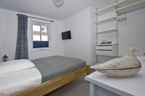 ein Schlafzimmer mit einem Bett und einer Schale auf einer Theke in der Unterkunft zentrale FeWo mit Balkon, gratis Nutzung vom AHOI Erlebnisbad und Sauna in Sellin - Villa Anni FeWo 05 in Göhren