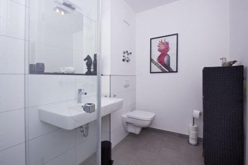 ein weißes Badezimmer mit Waschbecken und Toilette in der Unterkunft zentrale FeWo mit Balkon, gratis Nutzung vom AHOI Erlebnisbad und Sauna in Sellin - Villa Anni FeWo 05 in Göhren