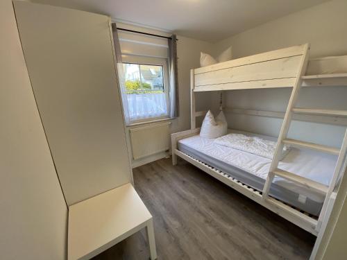 a small bedroom with a bunk bed and a window at Ferienhaus Solamar FeWo EG - Terrasse, Garten in Breege